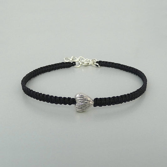 Black seven inch macramé bracelet with silver plated textured heart charm, lobster clasp and one inch extender chain.