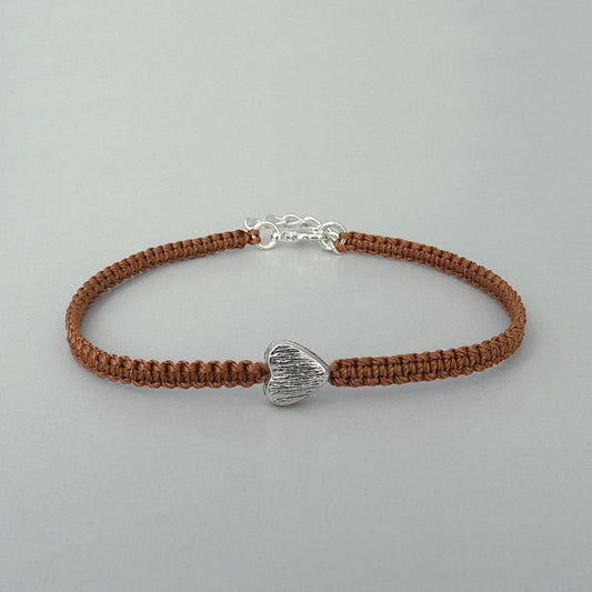 Copper coloured seven inch macramé bracelet with silver plated textured heart charm, lobster clasp and one inch extender chain.