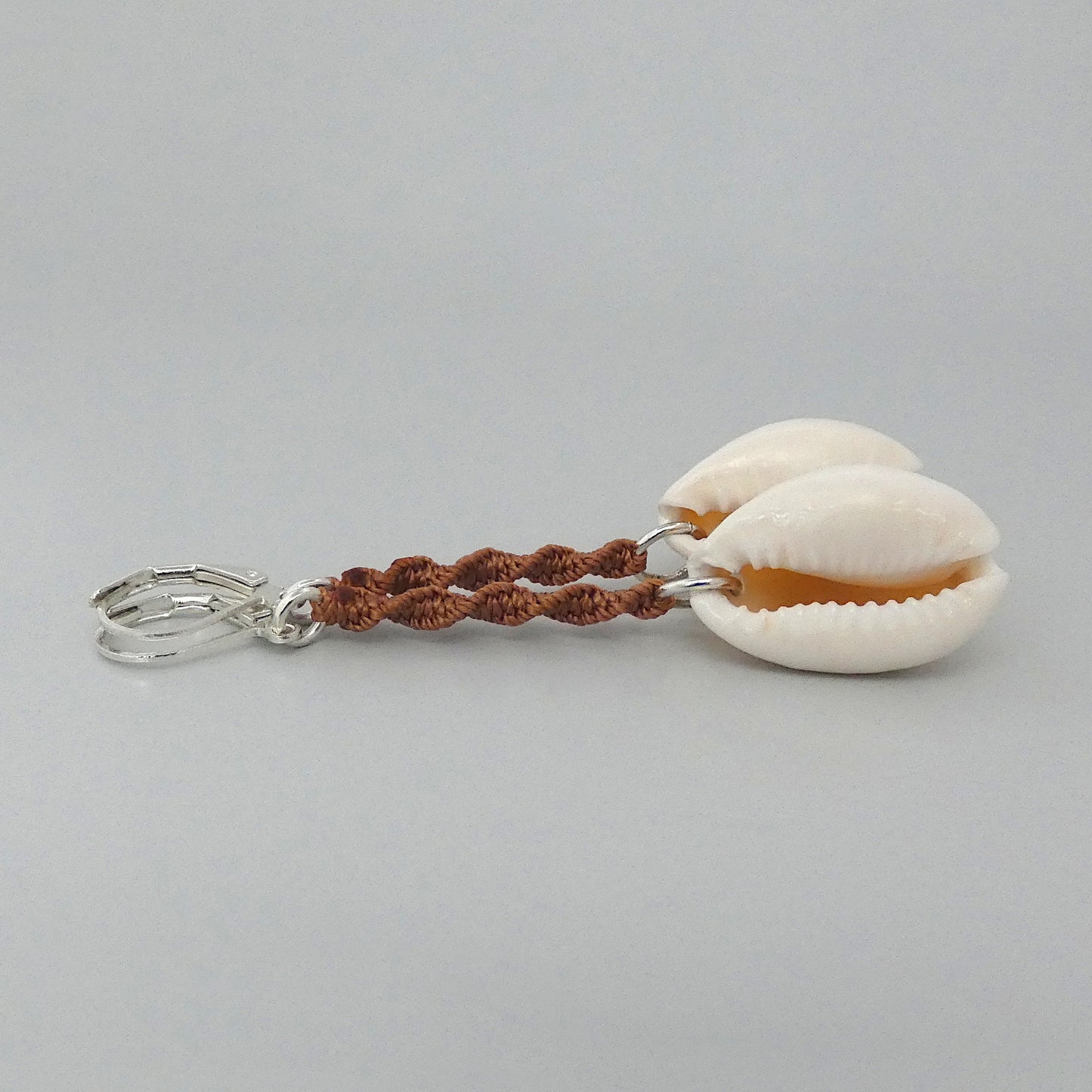 Silver plated leverback earrings with cowrie shells and copper coloured macramé twist detail.