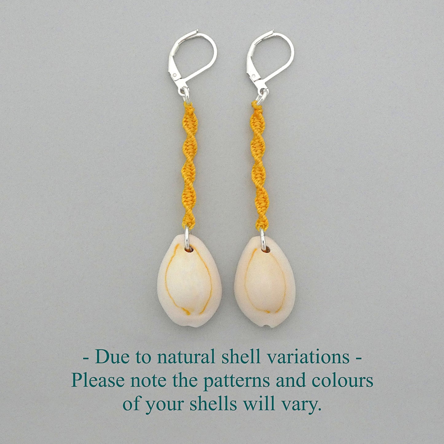 Silver plated leverback earrings with cowrie shells and golden yellow macramé twist detail.