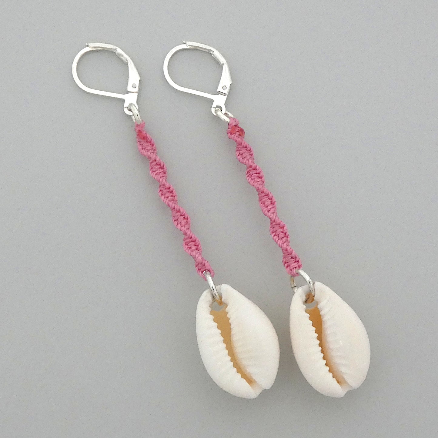 Silver plated leverback earrings with cowrie shells and pink macramé twist detail.