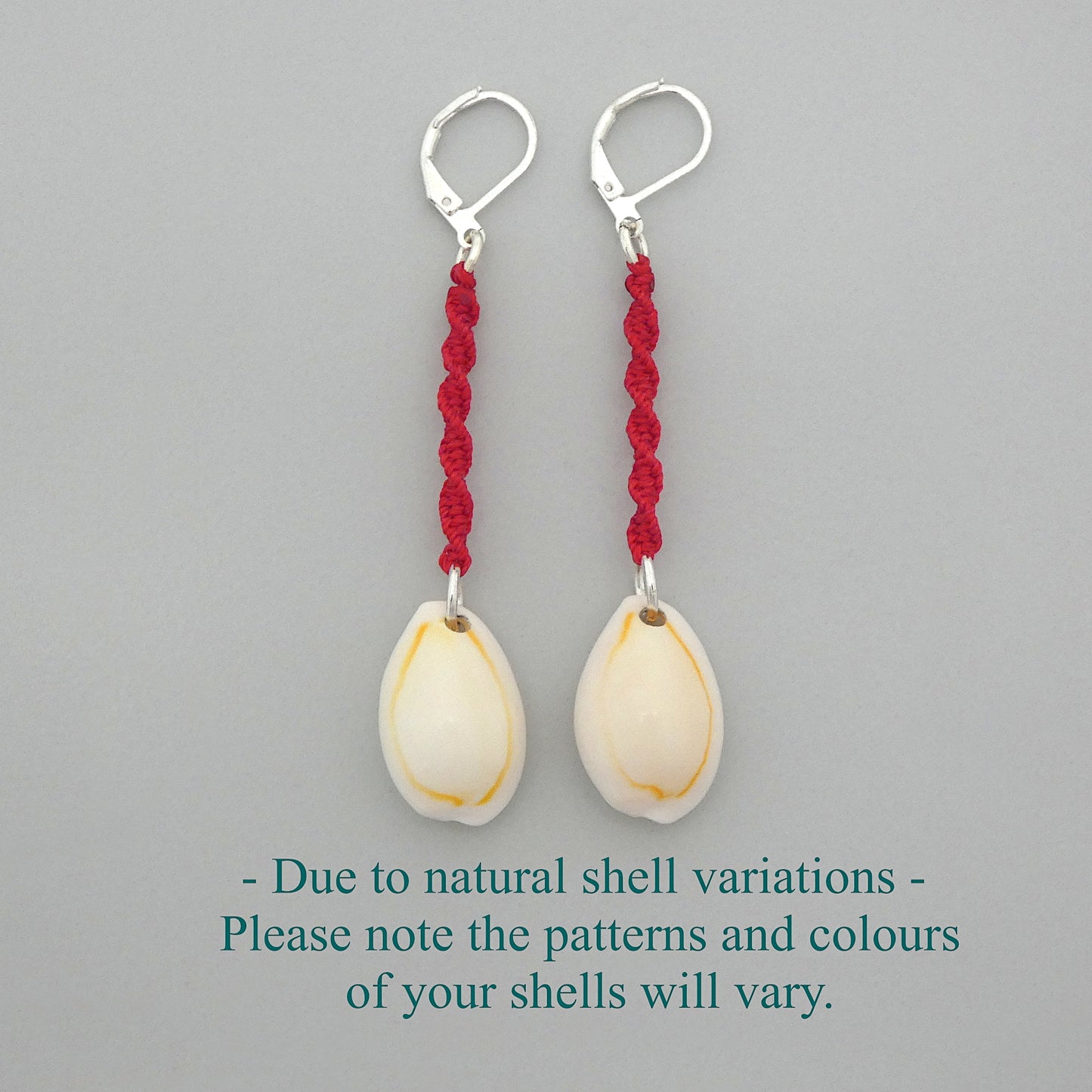 Silver plated leverback earrings with cowrie shells and bright red macramé twist detail.