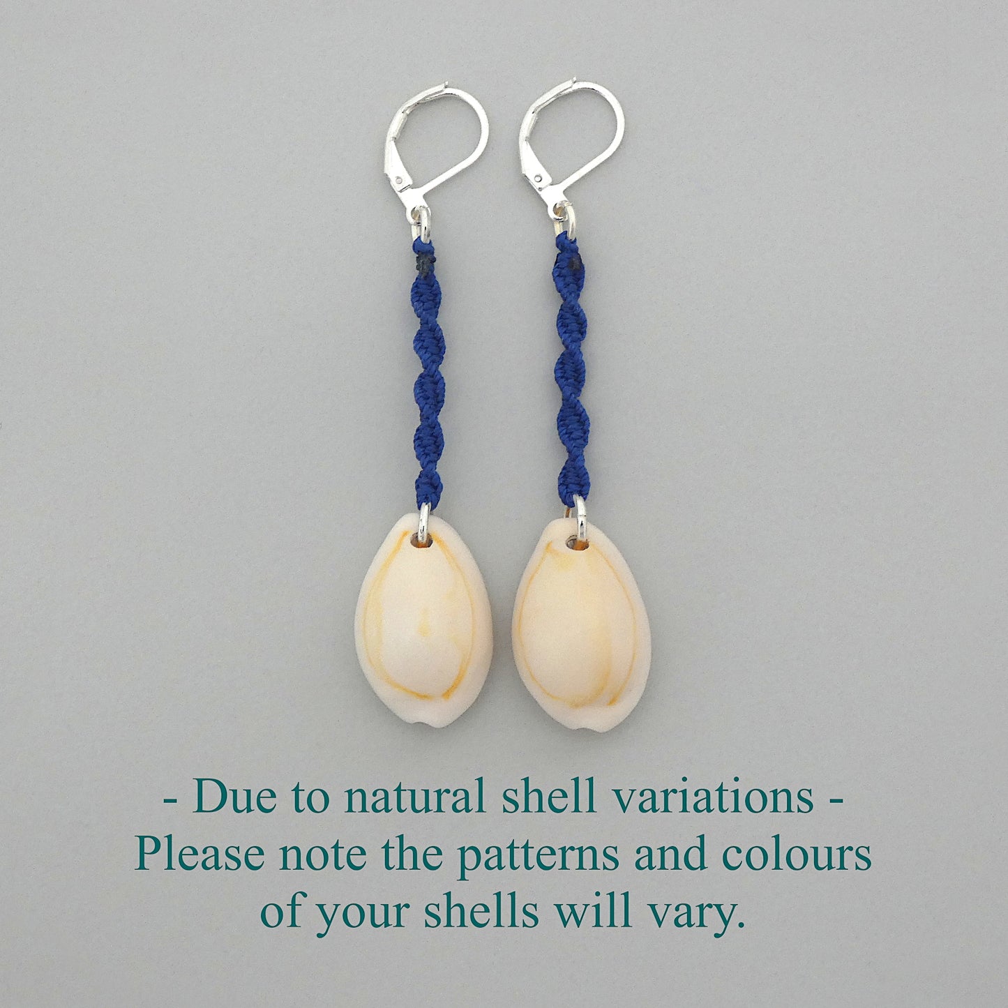 Silver plated leverback earrings with cowrie shells and royal blue macramé twist detail.