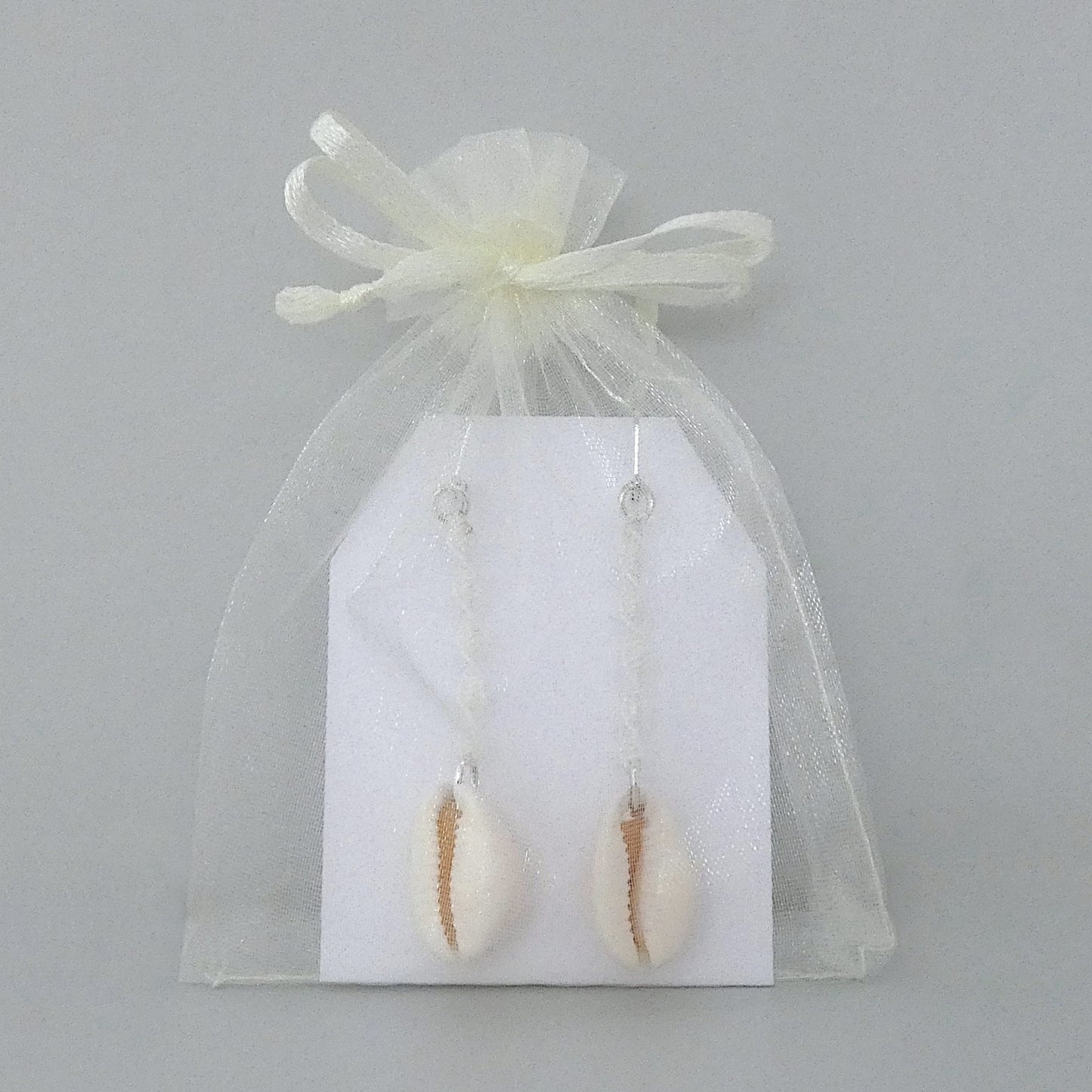 Silver plated leverback earrings with cowrie shells and white macramé twist detail.